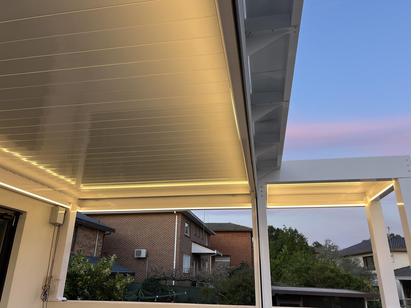 white louvre pergola with LED lighting on a Sydney balcony — Sword Sky outdoor installation